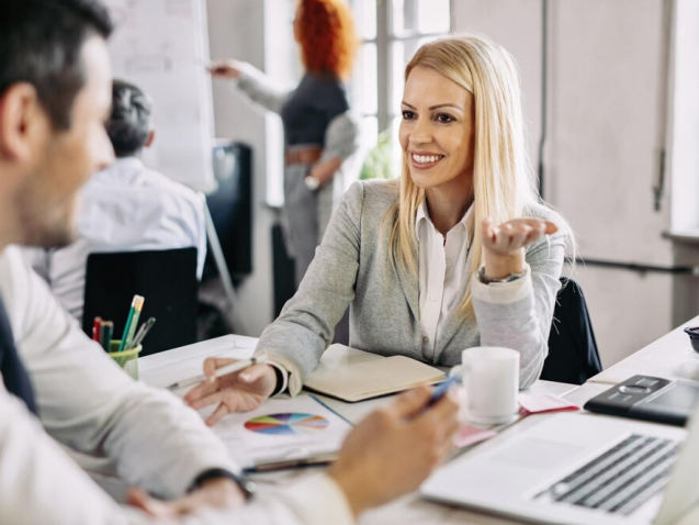 usmiechnieta-kobieta-w-srednim-wieku-rozmawia-i-rozwija-nowa-strategie-biznesowa-ze-swoim-meskim-wspolpracownikiem-w-biurze-w-tle-sa-ludzie_637285-259